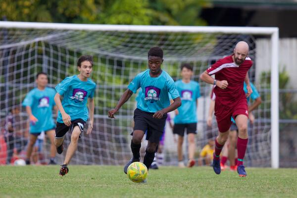 Young footballer in a blue jersey dribbles the ball during a match
